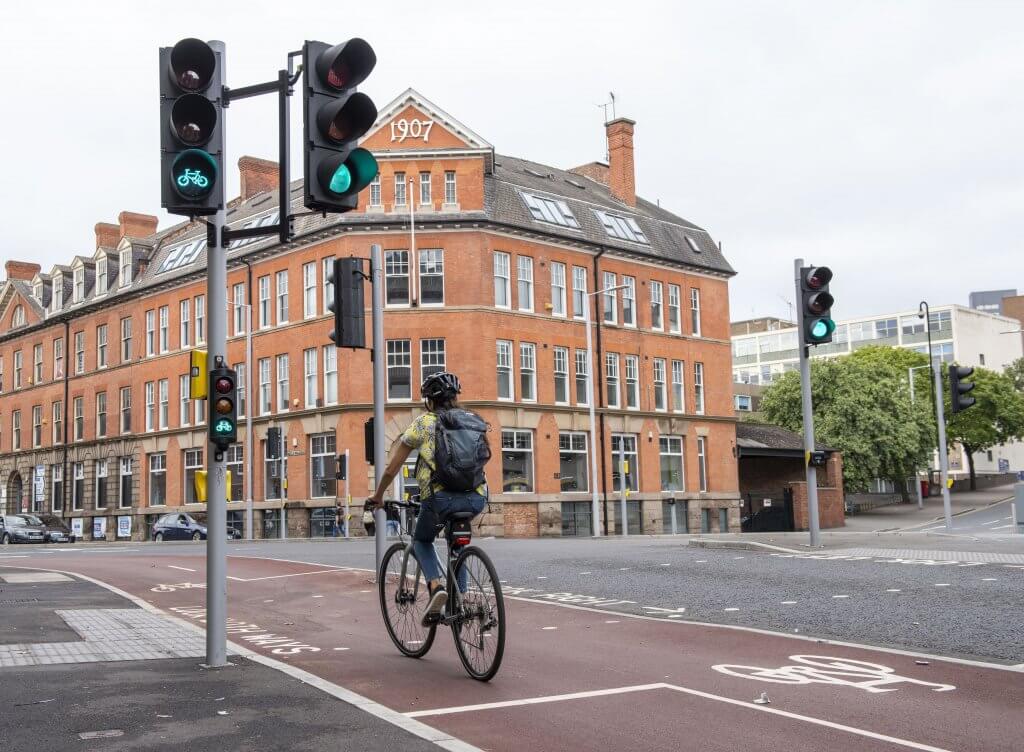A lady cycling through a traffic lights on green for cycles on the new cycle lane on Canal Street