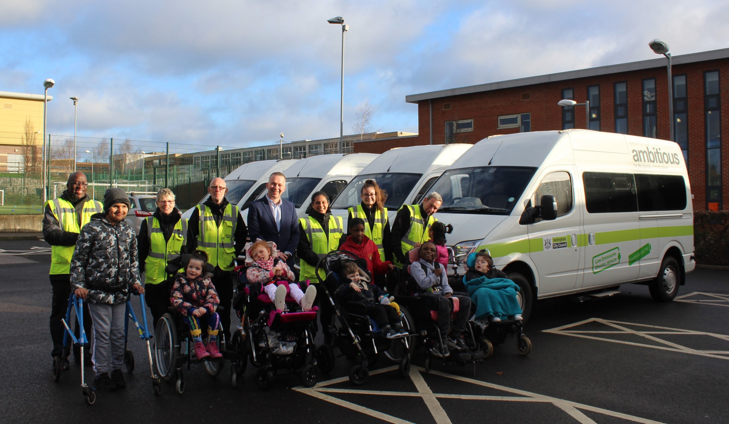 Children in front of new electric minibuses at Oakfield school