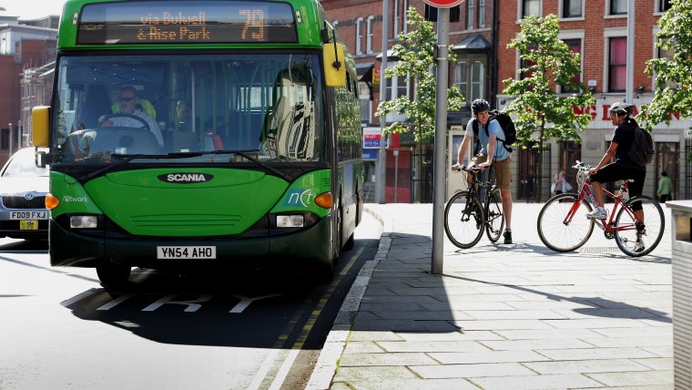 Cyclists standing next to a bus
