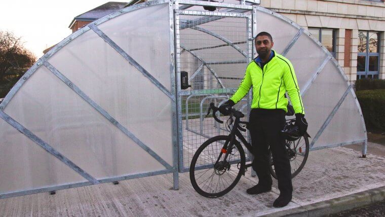 Experian Employee standing next to cycle shelter