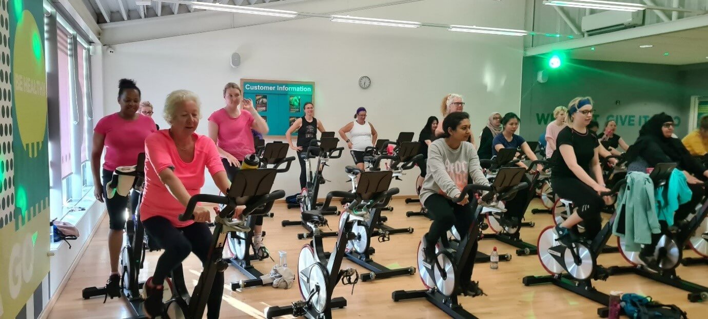 Women cycling together on stationary bikes