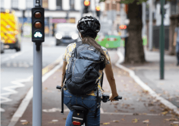 Female cyclist on designated cycle lane waiting for signals to change