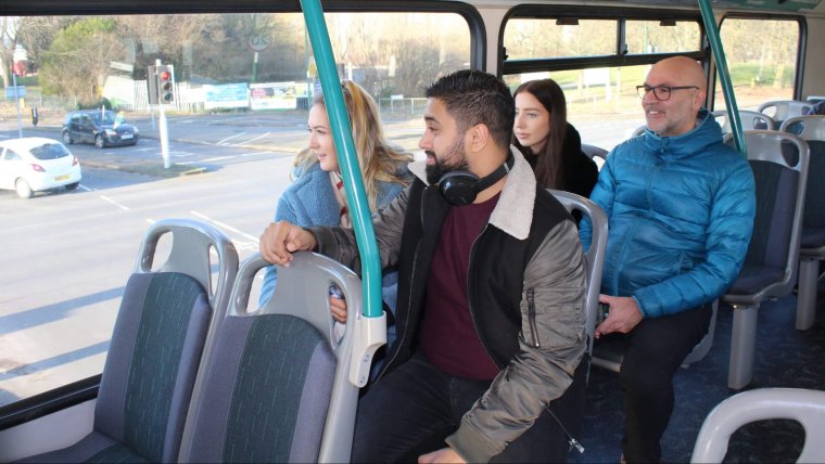 Four passengers travelling on a bus