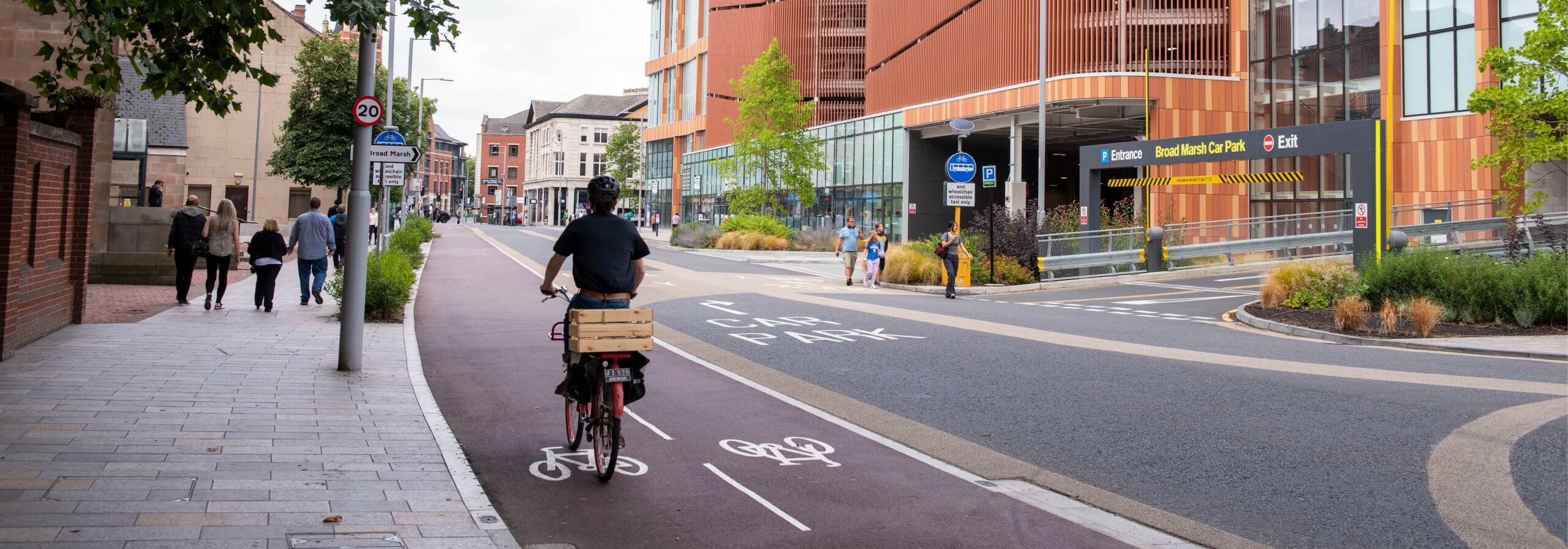 Cyclist in a segregated cycle path moving past the new Broad Marsh car park