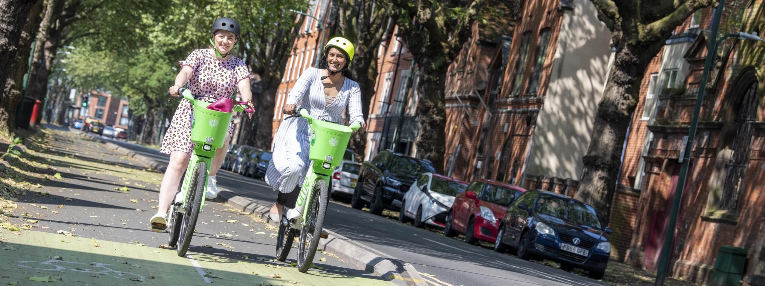 Two women riding e-bikes down castle blvd in Nottingham