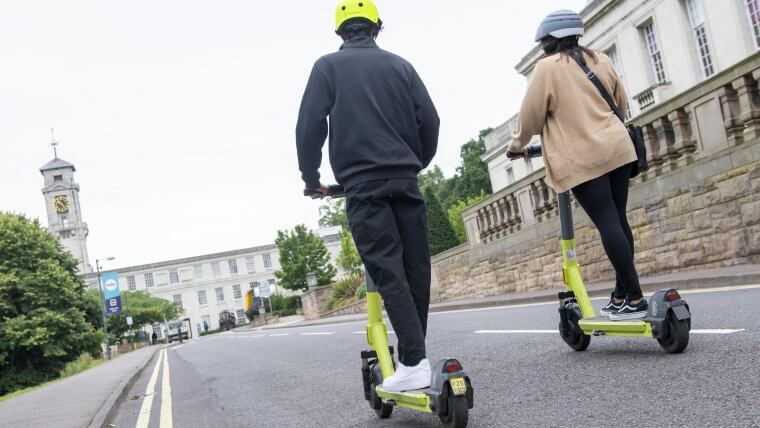 Two students on e-scooters on the University of Nottingham campus